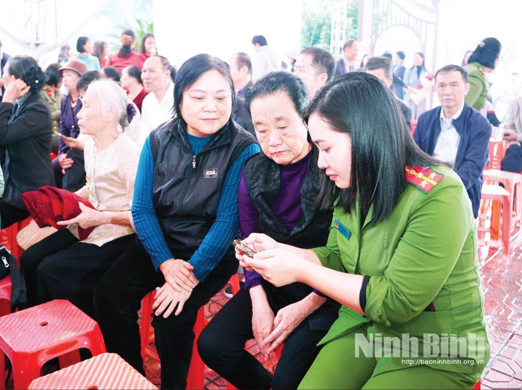 Cán bộ Công an phường Phủ Lý hướng dẫn người dân đóng góp ý kiến vào dự thảo các văn kiện trình Đại hội XIV của Đảng qua ứng dụng VNeID.