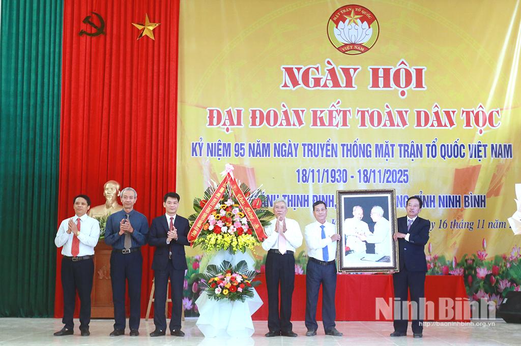 Đồng chí Nguyễn Đức Toàn, Ủy viên Ban Thường vụ Tỉnh ủy, Trưởng Ban Tuyên giáo và Dân vận Tỉnh ủy tặng bức ảnh “Bác Hồ và Bác Tôn bắt tay kết đoàn” và lẵng hoa chúc mừng cán bộ, Nhân dân thôn Khánh Thịnh Định.