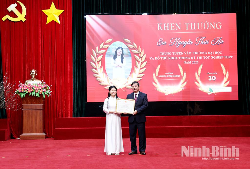 Đồng chí Bí thư Đảng ủy xã Phát Diệm trao thưởng cho em Nguyễn Thái An, thủ khoa Trường Đại học Dược Hà Nội. Ảnh: Minh Quang