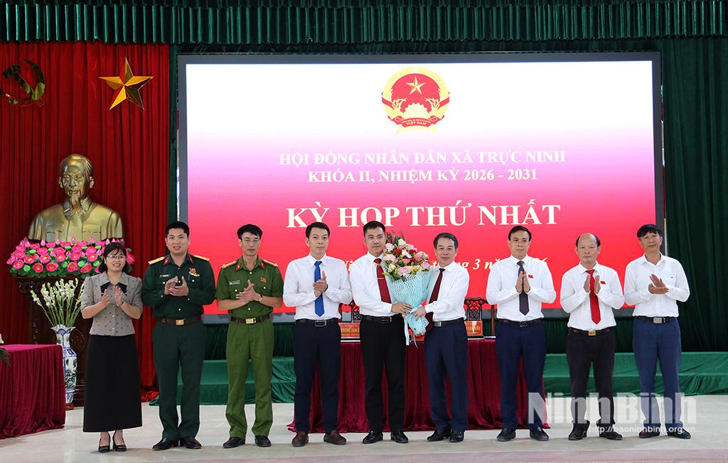 Đồng chí Bùi Hoàng Hà, Ủy viên Ban Thường vụ Tỉnh ủy, Phó Chủ tịch Thường trực HĐND tỉnh tặng hoa chúc mừng thành viên UBND xã Trực Ninh nhiệm kỳ 2026-2031.