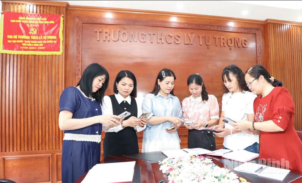 Đảng viên Chi bộ Trường THCS Lý Tự Trọng, thuộc Đảng bộ phường Hoa Lư sử dụng Sổ tay đảng viên điện tử phục vụ sinh hoạt chi bộ. Ảnh: Ngọc Ánh