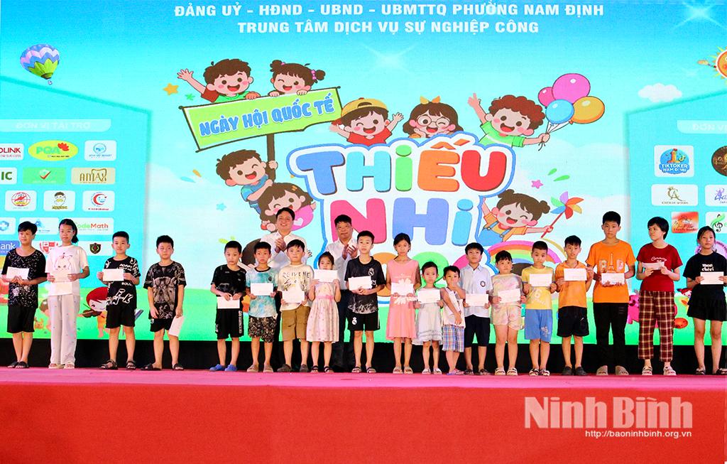 Đồng chí Trần Minh Thắng, Uỷ viên Ban Thường vụ Tỉnh uỷ, Bí thư Đảng uỷ, Chủ tịch HĐND phường Nam Định và các đại biểu tặng quà cho trẻ em có hoàn cảnh khó khăn.