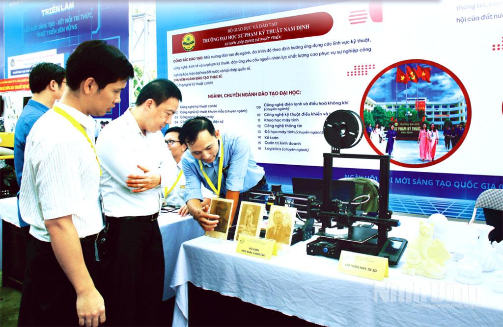 Các đại biểu tham quan gian hàng trưng bày mô hình máy khắc laser công nghệ cao của Trường Đại học Sư phạm Kỹ thuật Nam Định tại Triển lãm Đổi mới sáng tạo - Kết nối tri thức - Phát triển bền vững do Sở Khoa học và Công nghệ tổ chức.