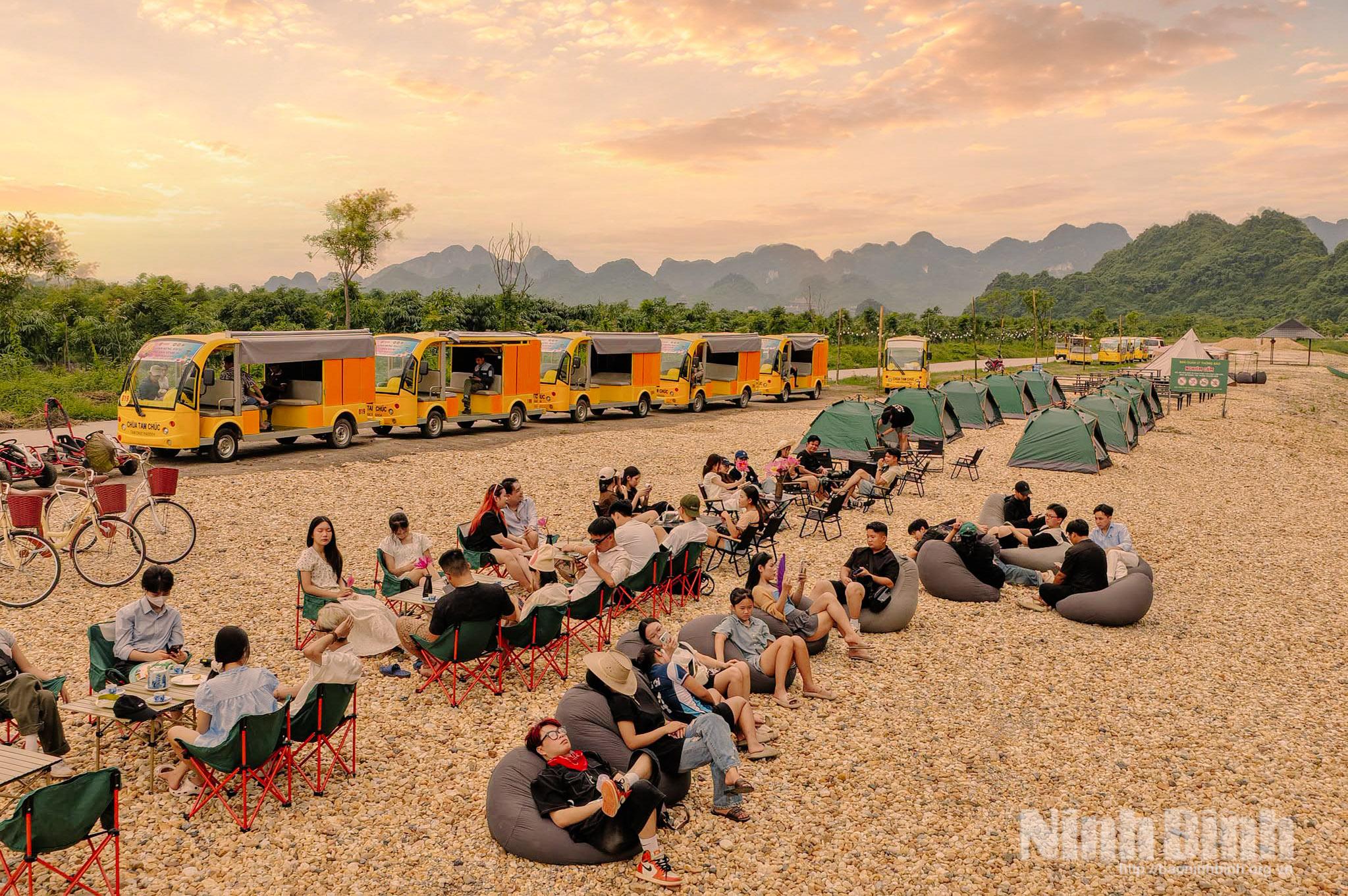 Những lều camping và xe lưu trú được bố trí bên bờ hồ, tạo nên không gian nghỉ dưỡng gần gũi với thiên nhiên.