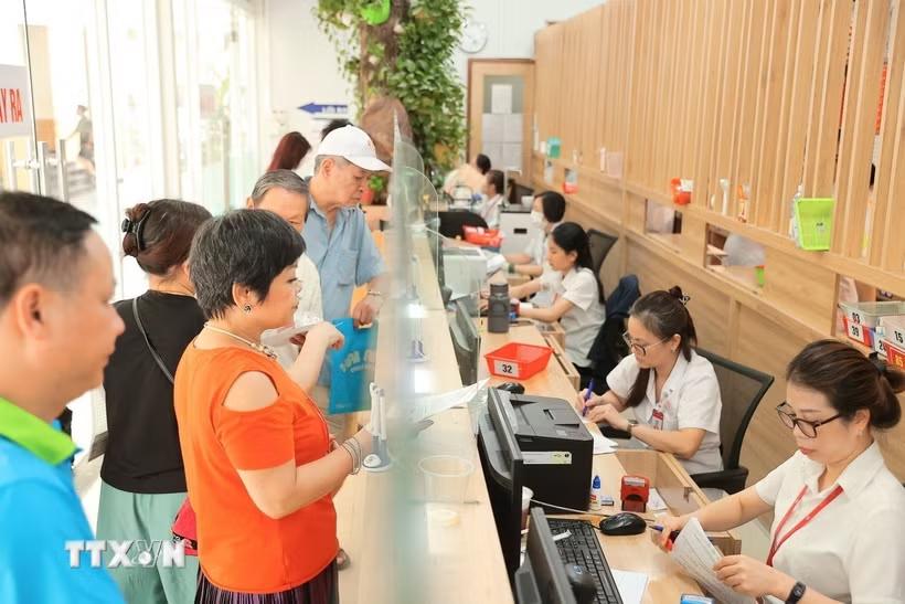 Người dân làm thủ tục khám chữa bệnh. (Ảnh: TTXVN)