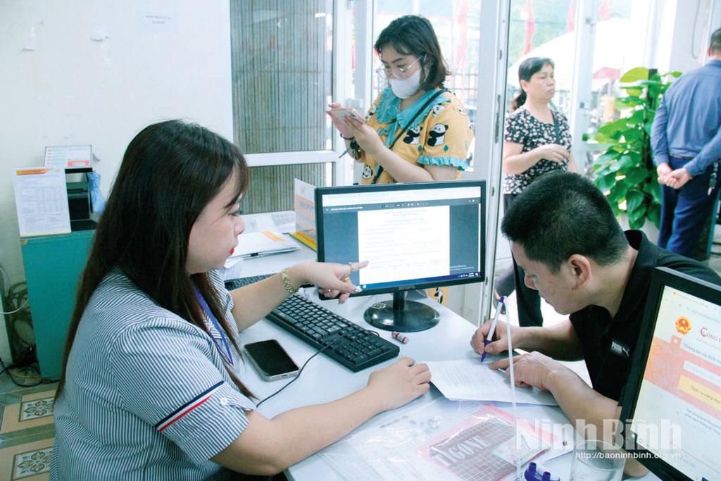 Cán bộ phường Nam Định hướng dẫn người dân tra cứu dịch vụ công trực tuyến trên bảng điện tử. Ảnh: Nguyễn Hương