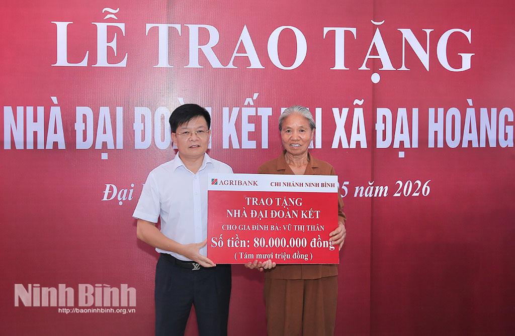 Lãnh đạo Agribank Chi nhánh tỉnh Ninh Bình trao biển hỗ trợ tiền cho gia đình bà Vũ Thị Thân.