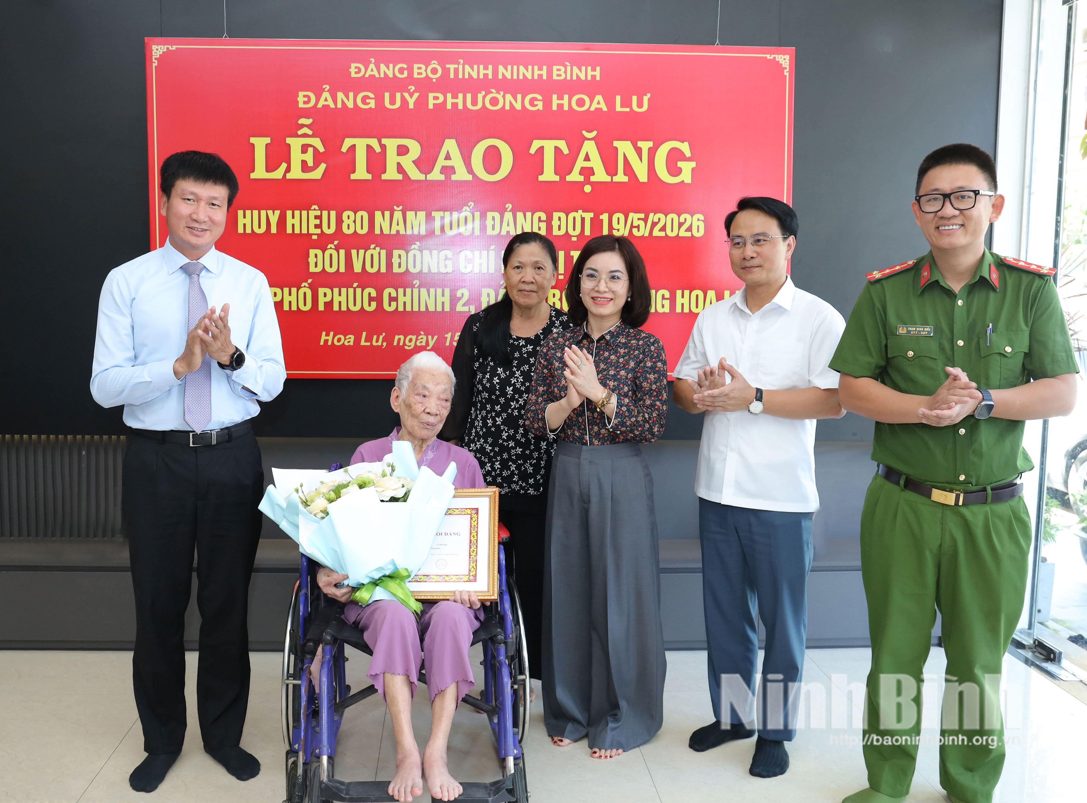 Đồng chí Trần Huy Tuấn, Ủy viên Trung ương Đảng, Bí thư Tỉnh ủy tặng hoa chúc mừng đồng chí Lê Thị Tuyết, đảng viên Chi bộ phố Phúc Chỉnh 2, Đảng bộ phường Hoa Lư.