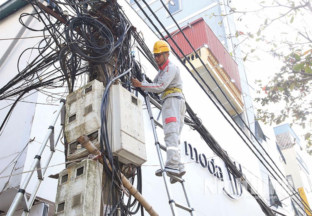 Nhân viên kỹ thuật Viettel Ninh Bình chỉnh trang, thu gọn cáp trên địa bàn phường Nam Định.