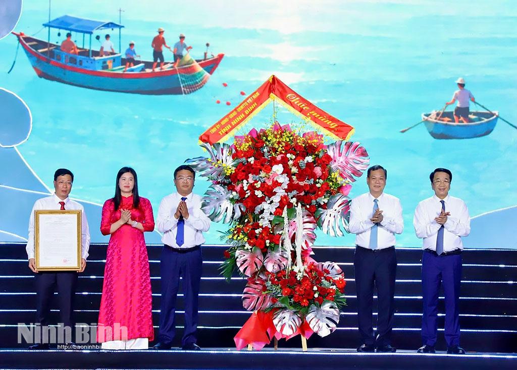 Đồng chí Lê Quốc Chỉnh, Phó Bí thư Tỉnh ủy, Chủ tịch Hội đồng nhân dân tỉnh tặng hoa chúc mừng xã Giao Ninh. Ảnh: Ngọc Linh