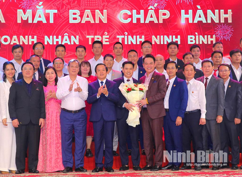 Đồng chí Hoàng Bình Quân, nguyên Ủy viên Trung ương Đảng, nguyên Trưởng Ban Đối ngoại Trung ương, Chủ tịch danh dự Hội Doanh nhân trẻ Việt Nam và các đồng chí lãnh đạo tỉnh tặng hoa chúc mừng Ban Chấp hành Hội Doanh nhân trẻ tỉnh Ninh Bình.