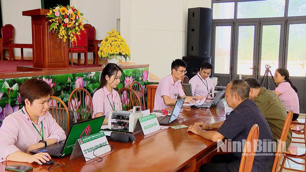 Cán bộ, nhân viên Tổ giao dịch xã của Phòng giao dịch NHCSXH Nho Quan hướng dẫn người dân hoàn thiện hồ sơ vay vốn.