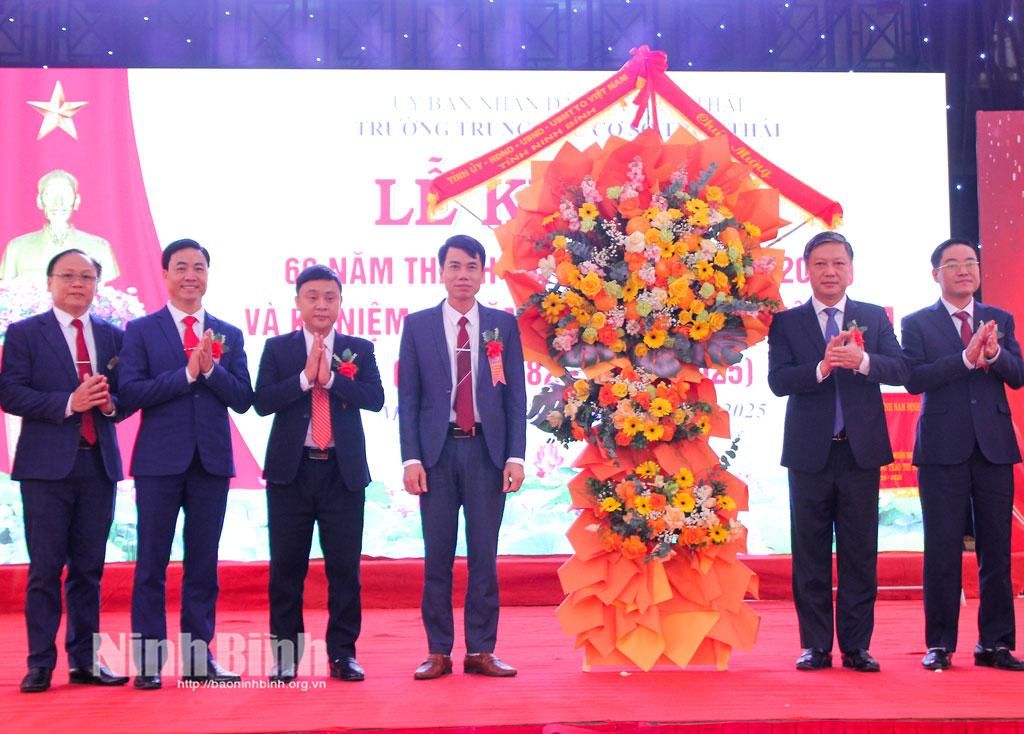 Đồng chí Đinh Việt Dũng, Ủy viên Ban Thường vụ Tỉnh ủy, Trưởng Ban Tổ chức Tỉnh ủy tặng hoa chúc mừng cán bộ, giáo viên Trường THCS Trực Thái.