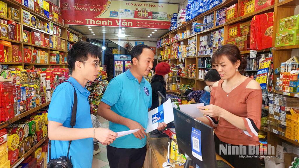 Cán bộ BHXH tỉnh Ninh Bình tuyên truyền về Cuộc thi trực tuyến “Tìm hiểu chính sách, pháp luật về BHXH, BHYT năm 2026” cho người kinh doanh tại địa bàn phường Hoa Lư.