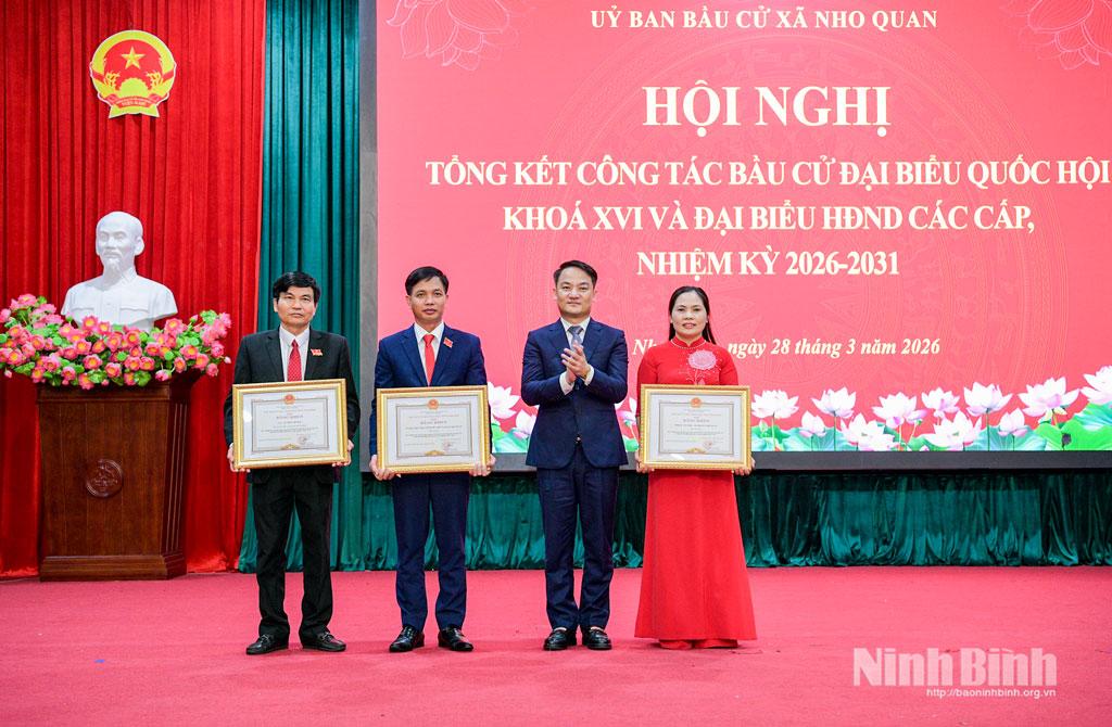 Đồng chí Lê Văn Thế, Tỉnh ủy viên, Phó Chánh Văn phòng Tỉnh ủy trao Bằng khen của UBND tỉnh cho các tập thể, cá nhân có thành tích xuất sắc trong công tác bầu cử đại biểu Quốc hội và đại biểu HĐND các cấp nhiệm kỳ 2026 - 2031 tại xã Nho Quan.