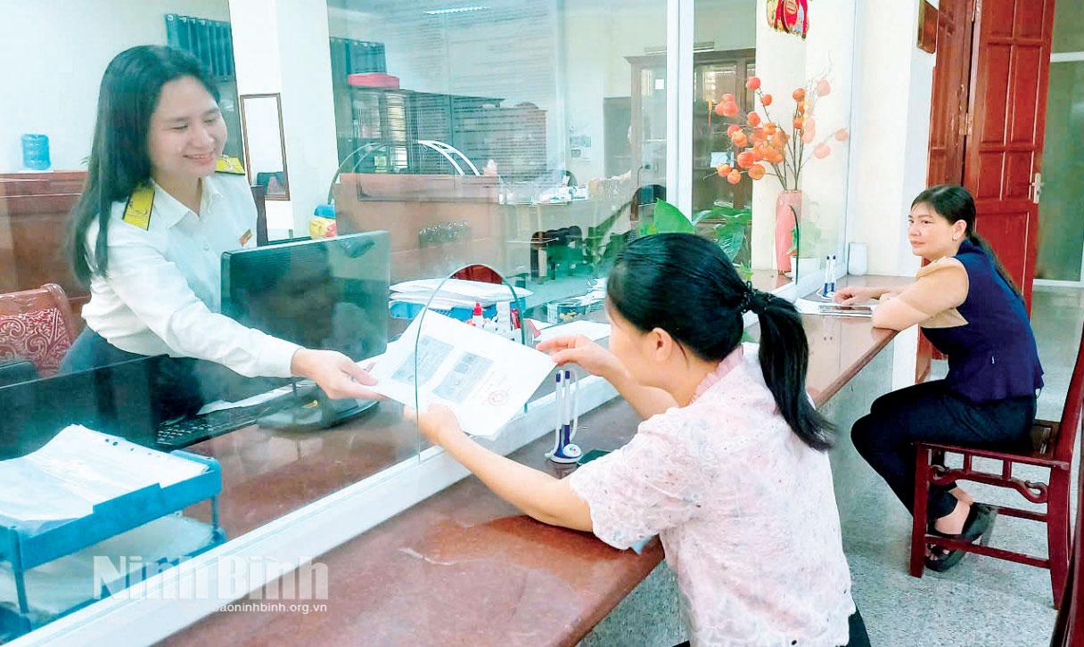 Cán bộ Thuế tỉnh Ninh Bình hướng dẫn người nộp thuế thực hiện thủ tục hành chính.