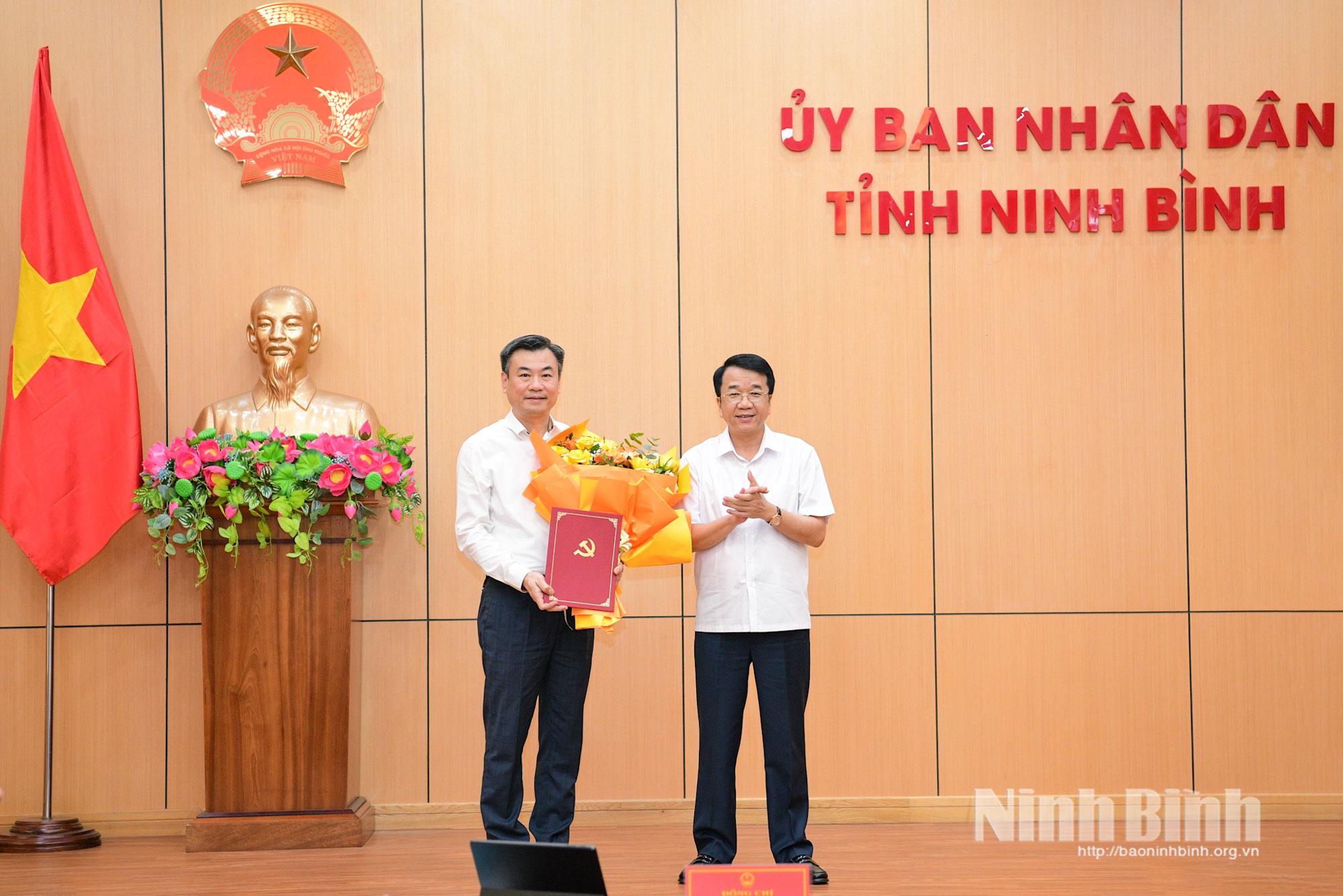 Đồng chí Nguyễn Thanh Bình, Phó Bí thư Tỉnh ủy, Bí thư Đảng ủy UBND tỉnh, Chủ tịch UBND tỉnh trao quyết định và tặng hoa chúc mừng đồng chí Trương Công Khải.