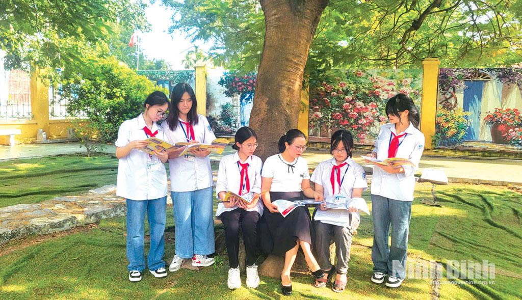 Cô và trò Trường THCS Lý Tự Trọng (phường Hoa Lư) cùng đọc và trao đổi nội dung sách.