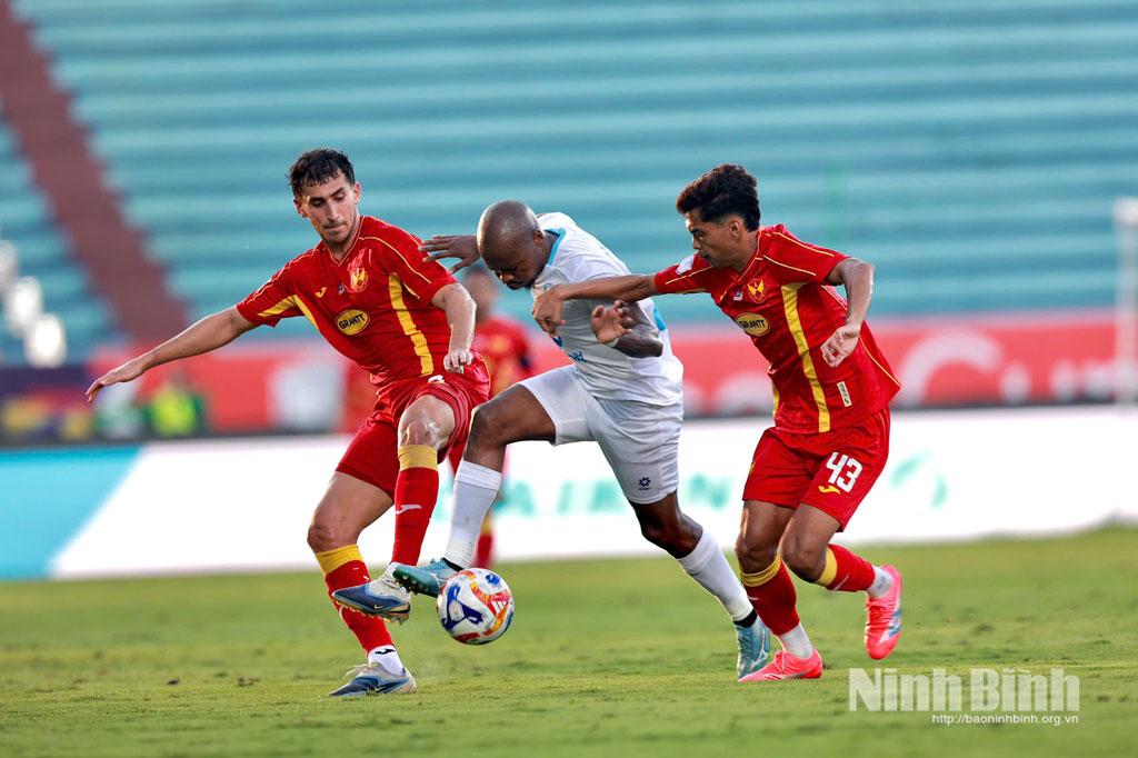 Tình huống tranh chấp bóng giữa cầu thủ Nam Định FC Percy Tau và các cầu thủ đội khách.