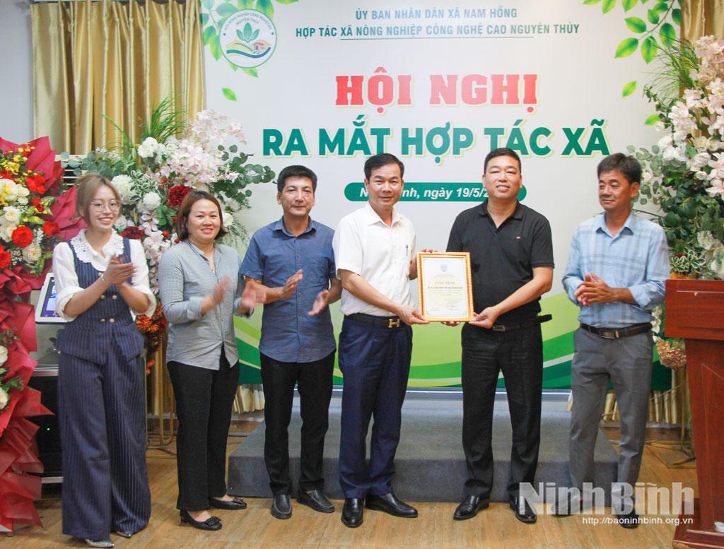 Lãnh đạo Liên minh HTX tỉnh trao giấy chứng nhận thành viên cho HTX nông nghiệp công nghệ cao xã Nam Hồng.