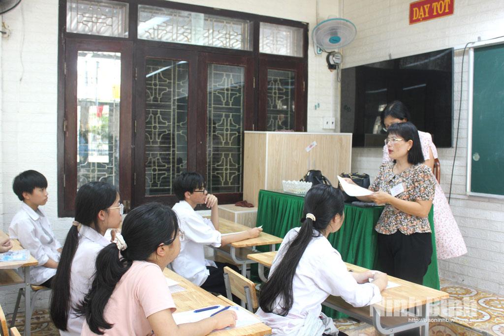 Giáo viên hướng dẫn thí sinh làm thủ tục dự thi tại điểm thi Trường THPT Chuyên Lê Hồng Phong.