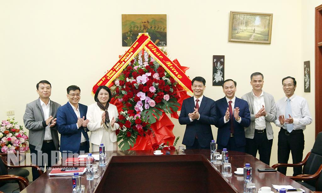 Đồng chí Nguyễn Đức Toàn, Uỷ viên Ban Thường vụ Tỉnh uỷ, Trưởng Ban Tuyên giáo và Dân vận Tỉnh uỷ tặng hoa chúc mừng tập thể cán bộ, giáo viên Trường THPT Lý Nhân. Ảnh: Trần Ích