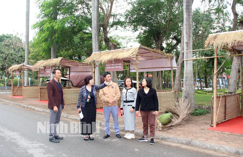 Nghệ nhân Lê Thị Thiết, Chủ tịch Hiệp hội Văn hóa ẩm thực tỉnh Ninh Bình trao đổi với các chủ gian hàng tham gia Liên hoan tại khu vực Bảo tàng Nam Định.