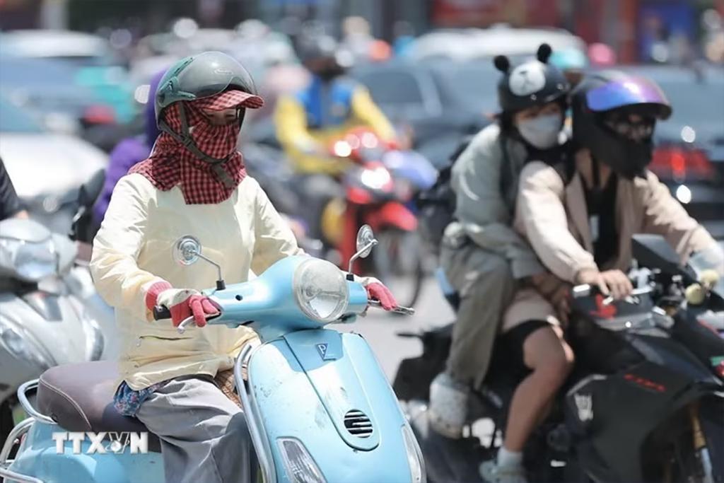 Người dân khi ra đường cần trang bị khăn, mũ, áo chống nắng. (Ảnh: Minh Quyết/TTXVN)