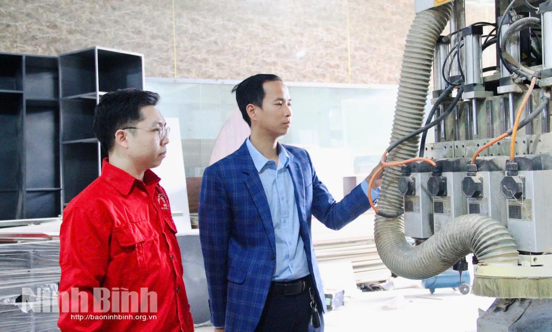 Aanh Nguyễn Ngọc Thương, Giám đốc Công ty TNHH Sản xuất cơ khí và thương mại Tuấn Ngọc (áo xanh) kiểm tra máy móc.