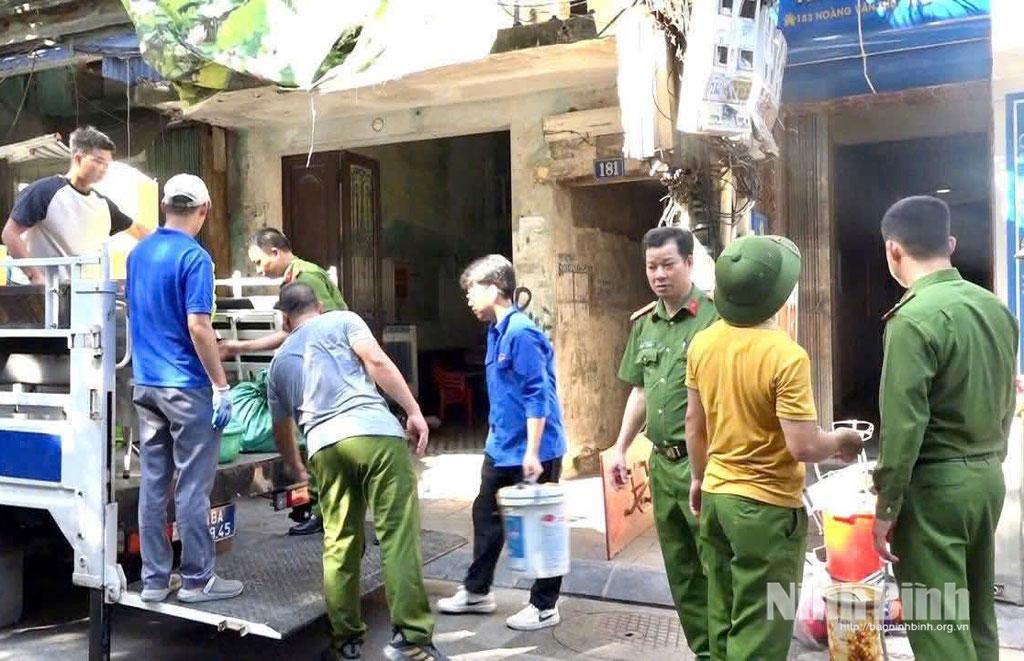 Lực lượng chức năng phường Nam Định hỗ trợ người dân di chuyển tài sản ra khỏi khu nhà nguy hiểm. Ảnh: CTV