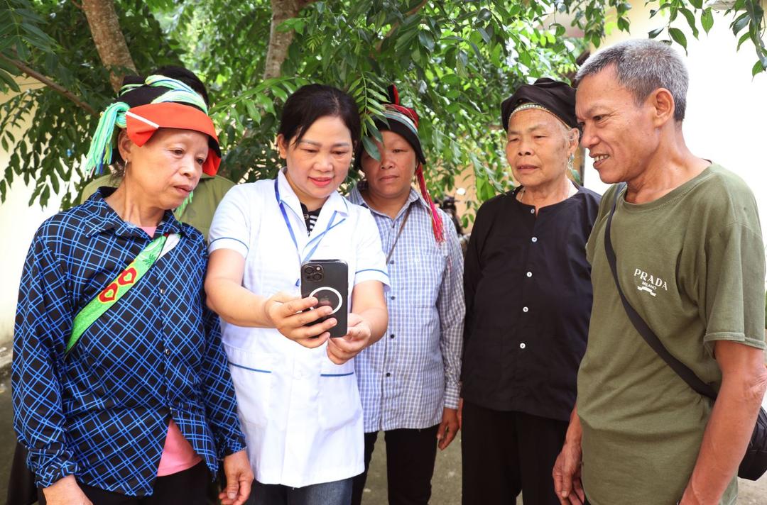 Cán bộ y tế xã biên giới Thanh Thủy (Tuyên Quang) hướng dẫn người dân sử dụng điện thoại thông minh, tiếp cận các dịch vụ số và ứng dụng công nghệ trong đời sống hằng ngày. Ảnh: TTXVN