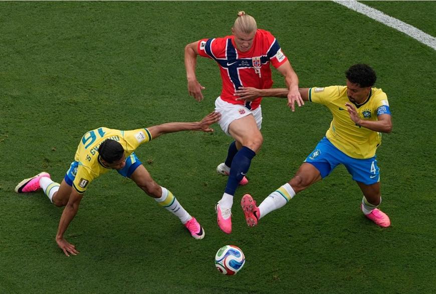 Erling Haaland tranh chấp quyết liệt giữa vòng vây của hai cầu thủ Brazil. Ảnh: AP.