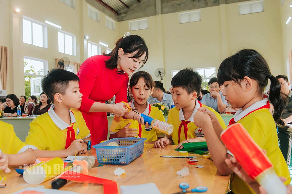 Giáo viên hướng dẫn học sinh làm nhạc cụ.