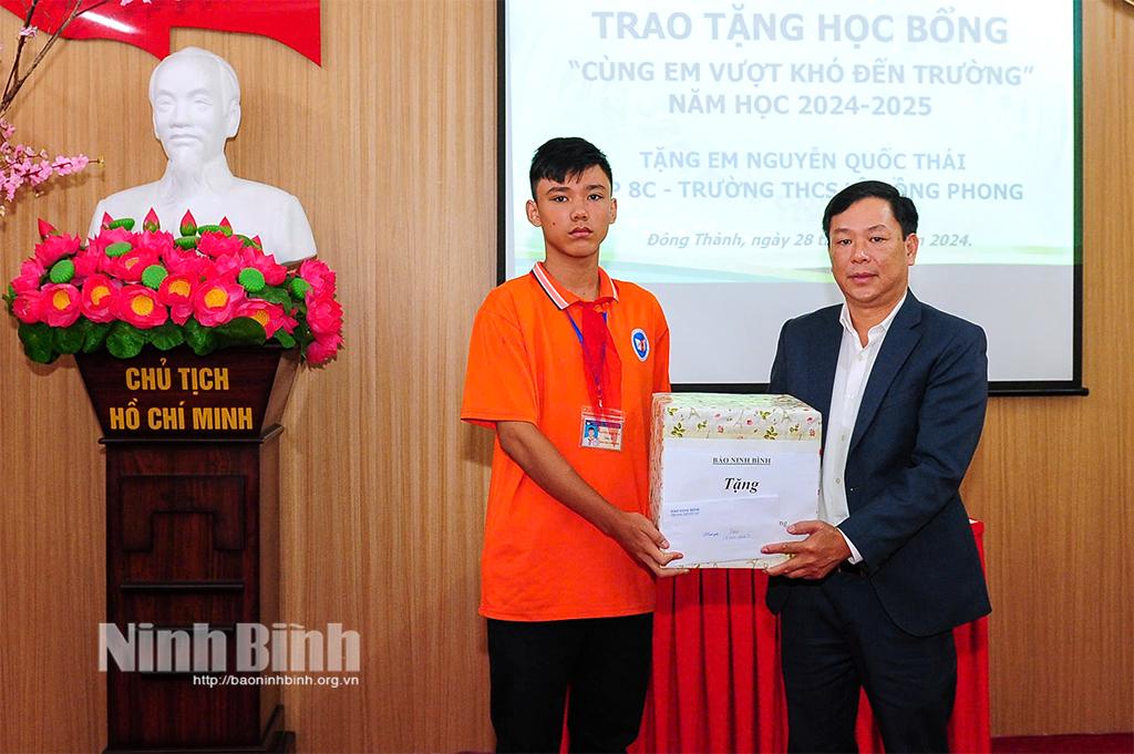 Đồng chí Bùi Ngọc Quang, Tổng Biên tập Báo Ninh Bình trao học bổng cho em Nguyễn Quốc Thái (lớp 8C, Trường THCS Lê Hồng Phong).