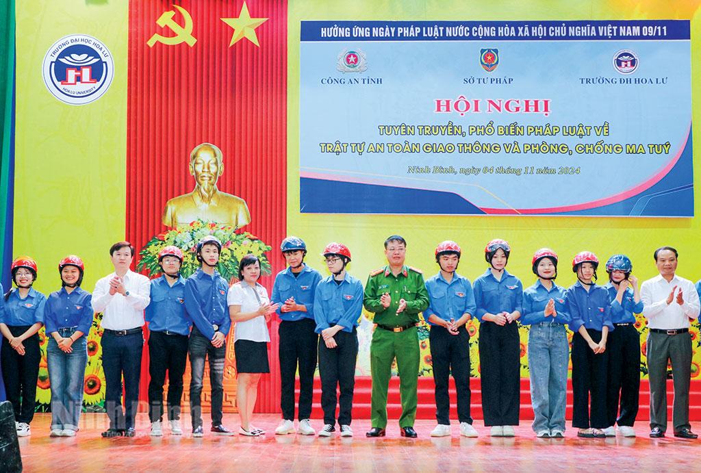 Lãnh đạo Công an tỉnh, Sở Giao thông-Vận tải, Sở Tư pháp trao mũ bảo hiểm cho sinh viên Trường Đại học Hoa Lư nhân Ngày Pháp luật Việt Nam 9/11. Ảnh: Đức Lam