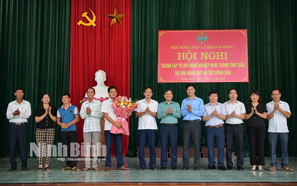 Các đại biểu tặng hoa chúc mừng thành viên tổ hội nghề nghiệp nuôi trồng thủy sản xã Khánh Hồng.