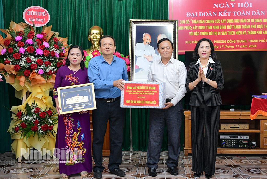 Đồng chí Phó Chủ tịch Quốc hội Nguyễn Thị Thanh trao tặng bức tranh Tòa nhà Quốc hội và quà cho khu dân cư phố 4, phường Đông Thành.