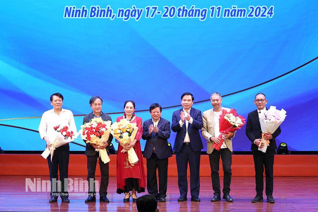 Đồng chí Phó Chủ tịch Thường trực UBND tỉnh Tống Quang Thìn và PGS.TS, nhạc sĩ Đỗ Hồng Quân, Phó Chủ tịch Ủy ban Trung ương MTTQ Việt Nam, Chủ tịch Liên hiệp các hội văn học nghệ thuật Việt Nam tặng hoa chúc mừng Ban giám khảo.