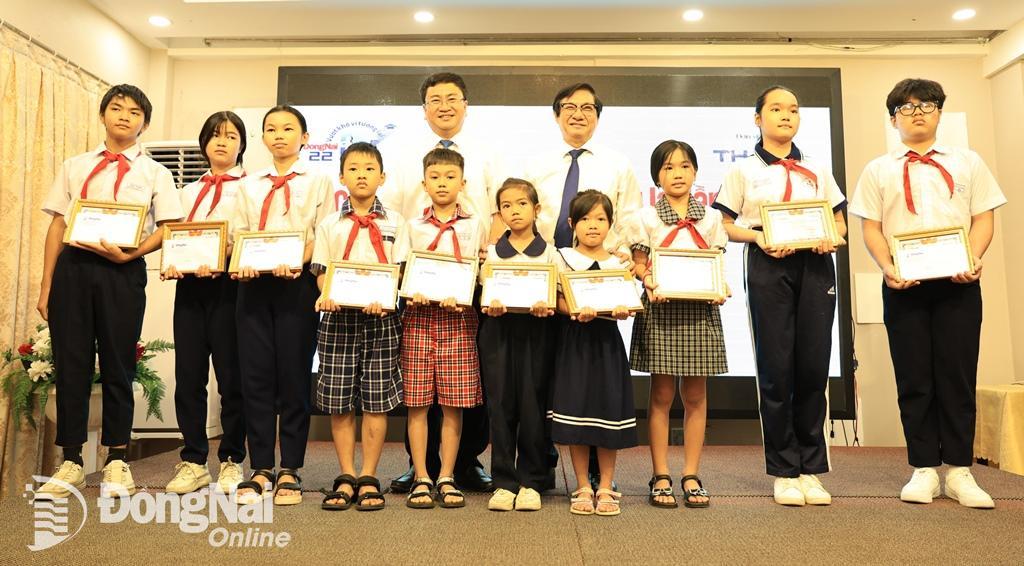 Phó Chủ tịch UBND tỉnh Nguyễn Sơn Hùng và Tổng biên tập Báo Đồng Nai Đào Văn Tuấn trao học bổng cho các em học sinh đơn vị thành phố Biên Hòa.