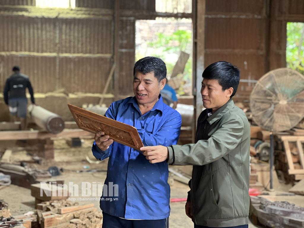 Nghệ nhân Vũ Văn Hạnh (áo xanh) đã có hơn 40 năm kinh nghiệm trong nghề dựng nhà gỗ cổ.