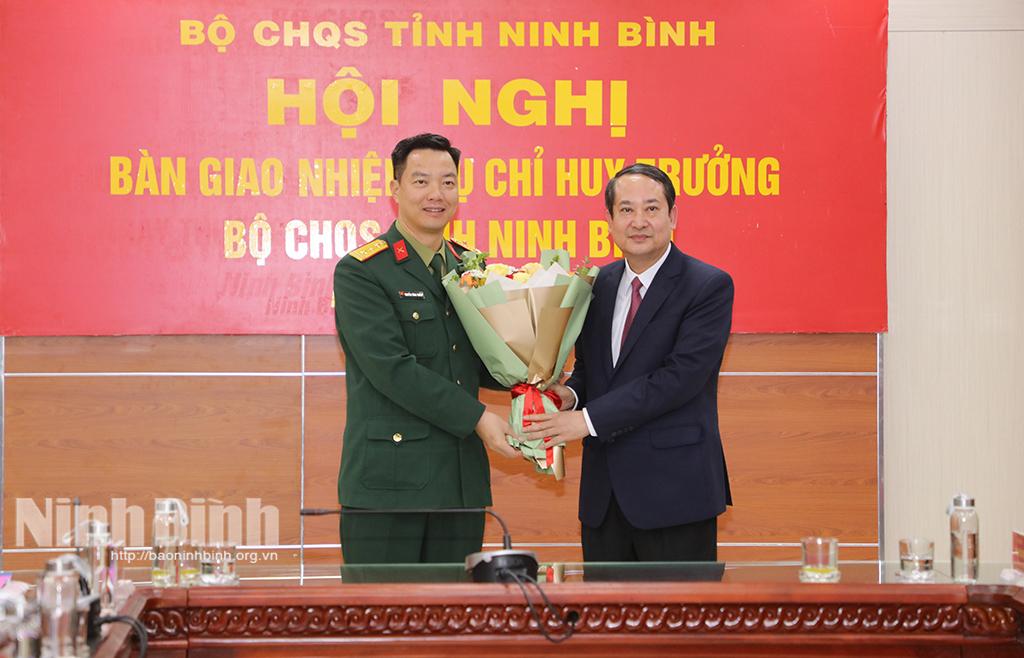 Đồng chí Phó Bí thư Thường trực Tỉnh uỷ, Chủ tịch HĐND tỉnh Mai Văn Tuất tặng hoa chúc mừng đồng chí tân Chỉ huy trưởng Bộ CHQS tỉnh.