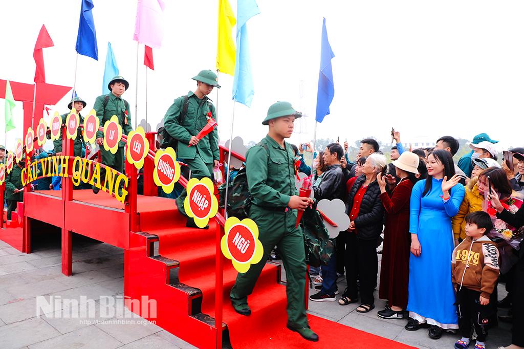 Các tân binh tại thành phố Hoa Lư bước qua cầu Vinh Quang tại lễ giao nhận quân. Ảnh: Đức Lam