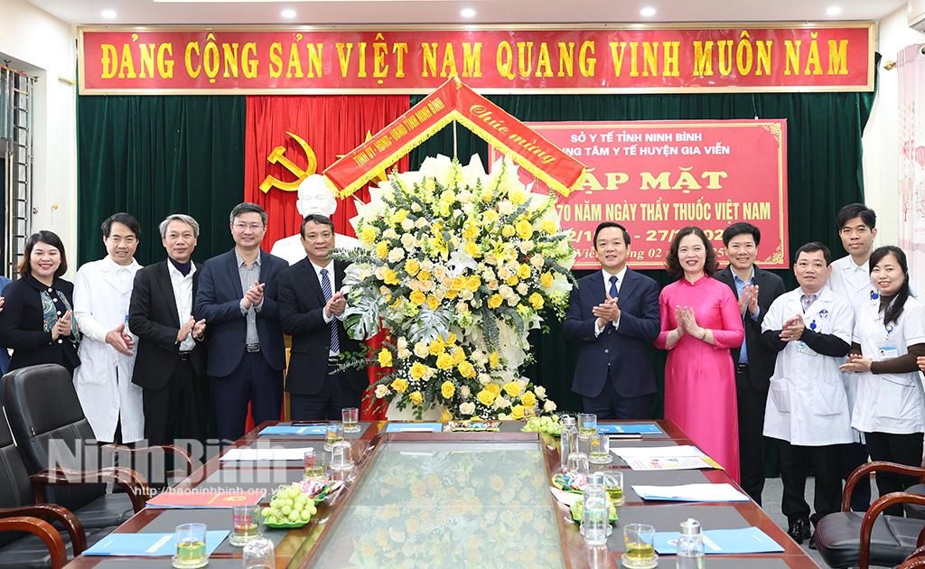 Đồng chí Phạm Quang Ngọc, Phó Bí thư Tỉnh uỷ, Chủ tịch UBND tỉnh tặng hoa chúc mừng tập thể lãnh đạo, cán bộ, y, bác sĩ Trung tâm Y tế huyện Gia Viễn.