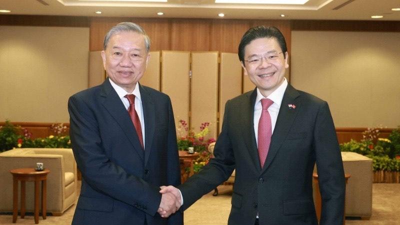 Tổng Bí thư Tô Lâm và Thủ tướng Singapore, Tổng Thư ký Đảng Hành động nhân dân Singapore (PAP) Lawrence Wong. (Ảnh: TTXVN)