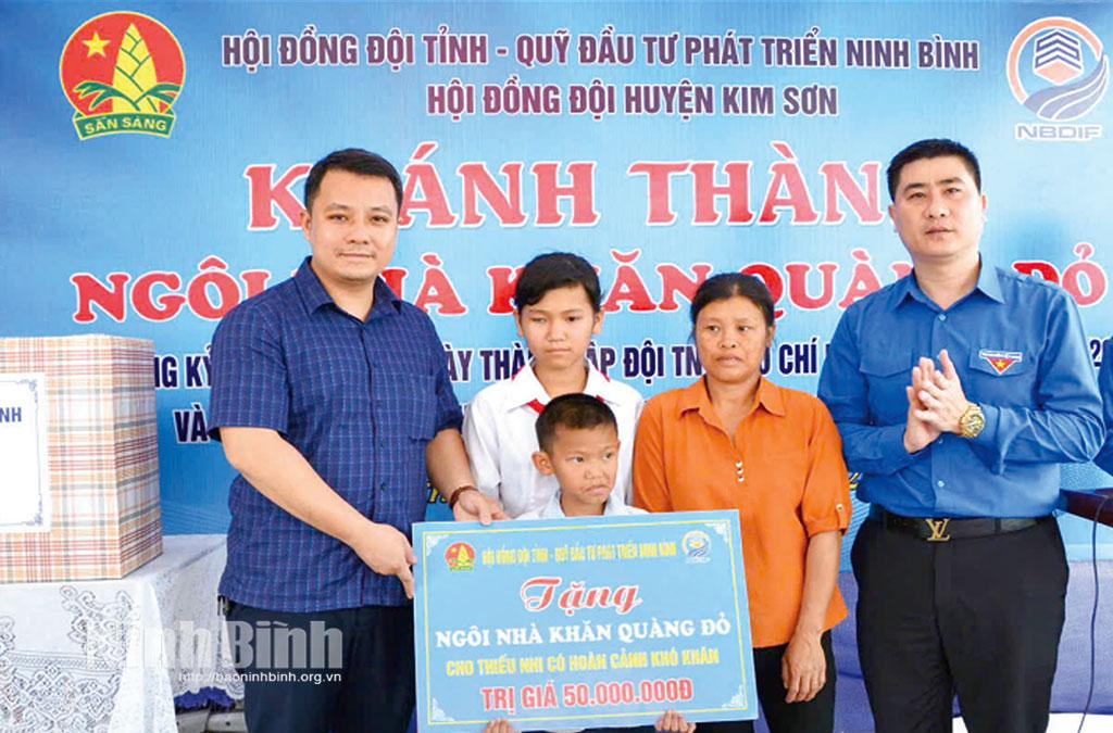Lãnh đạo Hội đồng Đội tỉnh, Quỹ Đầu tư phát triển Ninh Bình trao biển tượng trưng hỗ trợ xây dựng nhà “Khăn quàng đỏ” cho gia đình thiếu nhi có hoàn cảnh khó khăn tại huyện Kim Sơn. Ảnh: P.V