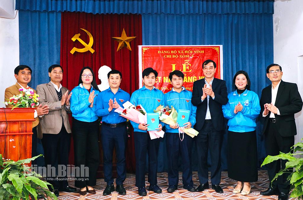Lãnh đạo Tỉnh đoàn và chính quyền xã Hồi Ninh (Kim Sơn) tặng hoa chúc mừng anh em song sinh Nguyễn Duy Quang và Nguyễn Thành Vinh được kết nạp vào Đảng trước khi lên đường nhập ngũ. Ảnh: Đức Lam