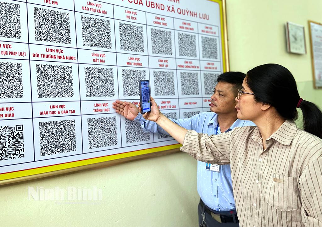 Công chức Bộ phận Tiếp nhận và Trả kết quả xã Quỳnh Lưu (Nho Quan) hướng dẫn công dân quét mã QR tra cứu TTHC.