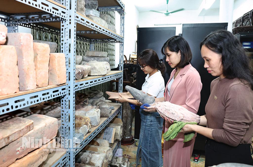 Nhân viên Bảo tàng tỉnh chuẩn bị tài liệu, hiện vật trưng bày tại Lễ hội Hoa Lư năm 2025. Ảnh: Minh Quang