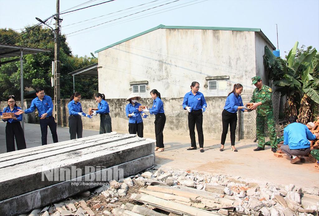 Đoàn viên, thanh niên tham gia hỗ trợ người dân vận chuyển vật liệu xây dựng nhà mới tại huyện Kim Sơn.