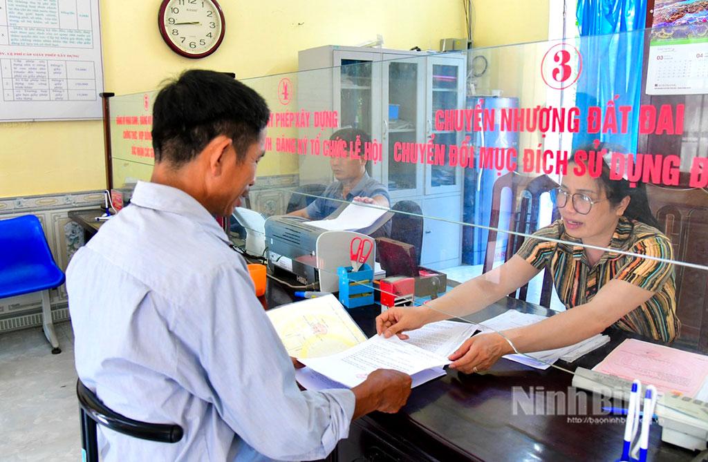 Cán bộ tại Bộ phận một cửa xã Khánh Thượng (Yên Mô) hướng dẫn người dân thực hiện thủ tục hành chính. Ảnh: Hồng Giang